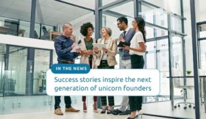 Success stories inspire the next generation of unicorn founders. Background image shows a diverse group of entrepreneurs celebrating business success in a bright office environment.