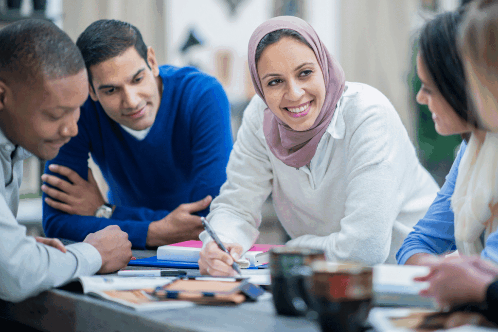 Three individuals sitting at a table while having a discussion
